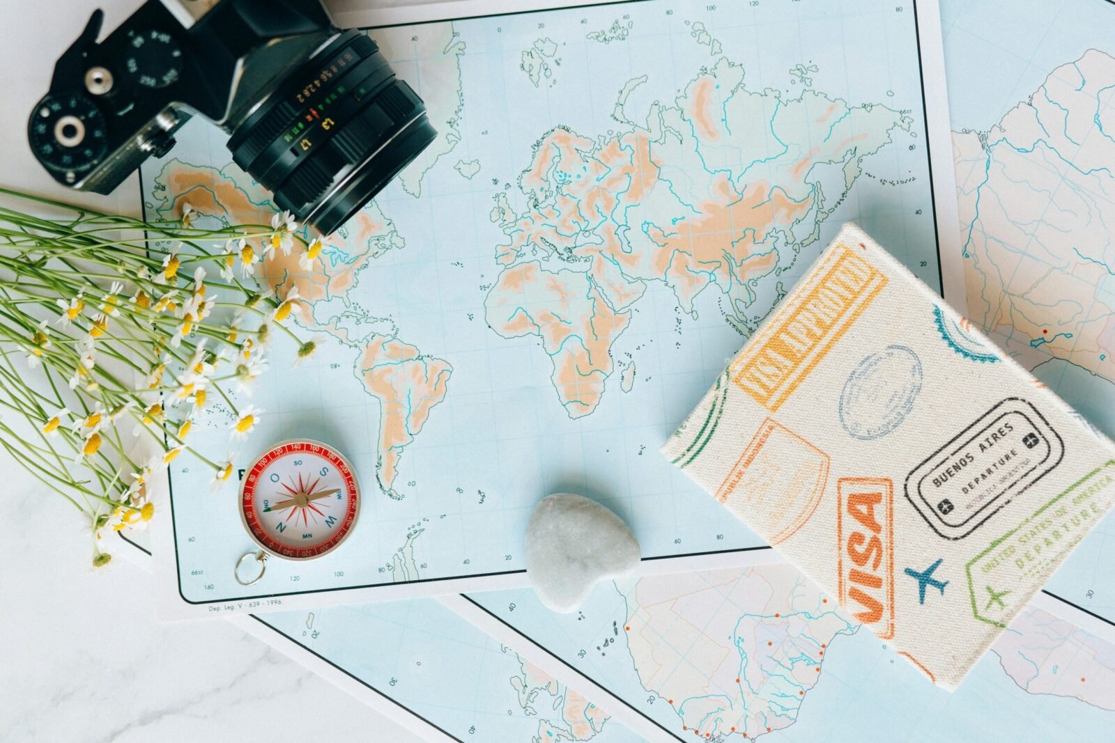 visit visa for students Flat lay of travel essentials: maps, camera, compass, and travel journal for planning adventures.